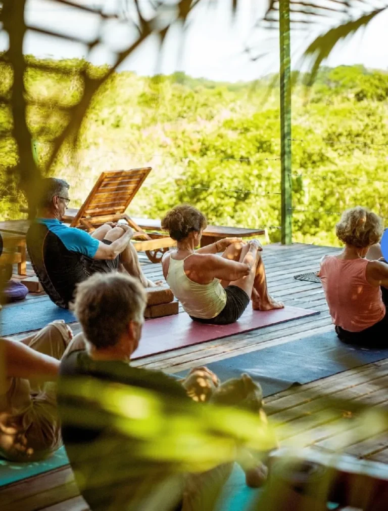 Group yoga practice on an open-air deck overlooking the Pacific at Calamocha Lodge