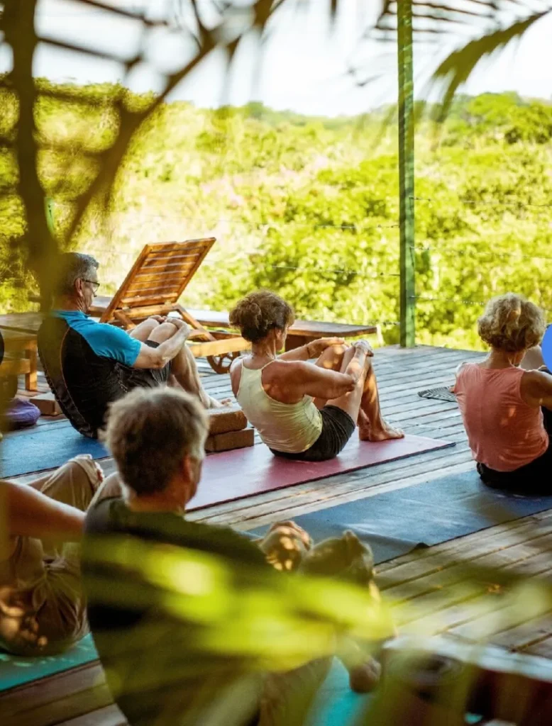 Group yoga practice on an open-air deck overlooking the Pacific at Calamocha Lodge