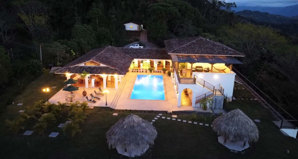 Hacienda Las Vainillas illuminated at night against the rainforest