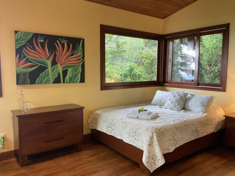 Bedroom with corner windows opening onto the forest canopy, Costa Rica retreat accommodation