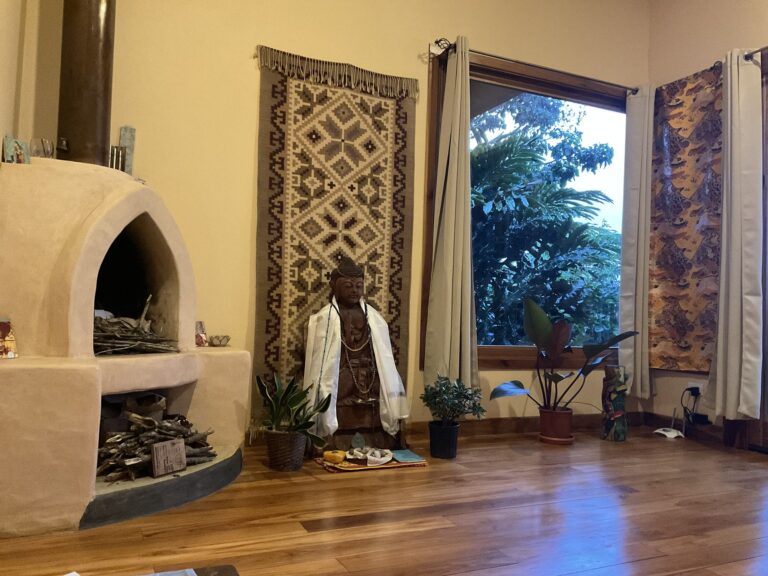 Adobe fireplace and Buddha room with woven textiles and a garden window, Costa Rica retreat centre
