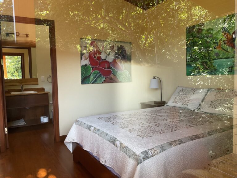 Bedroom with an en-suite bathroom, quilted bed and garden view, Costa Rica retreat centre