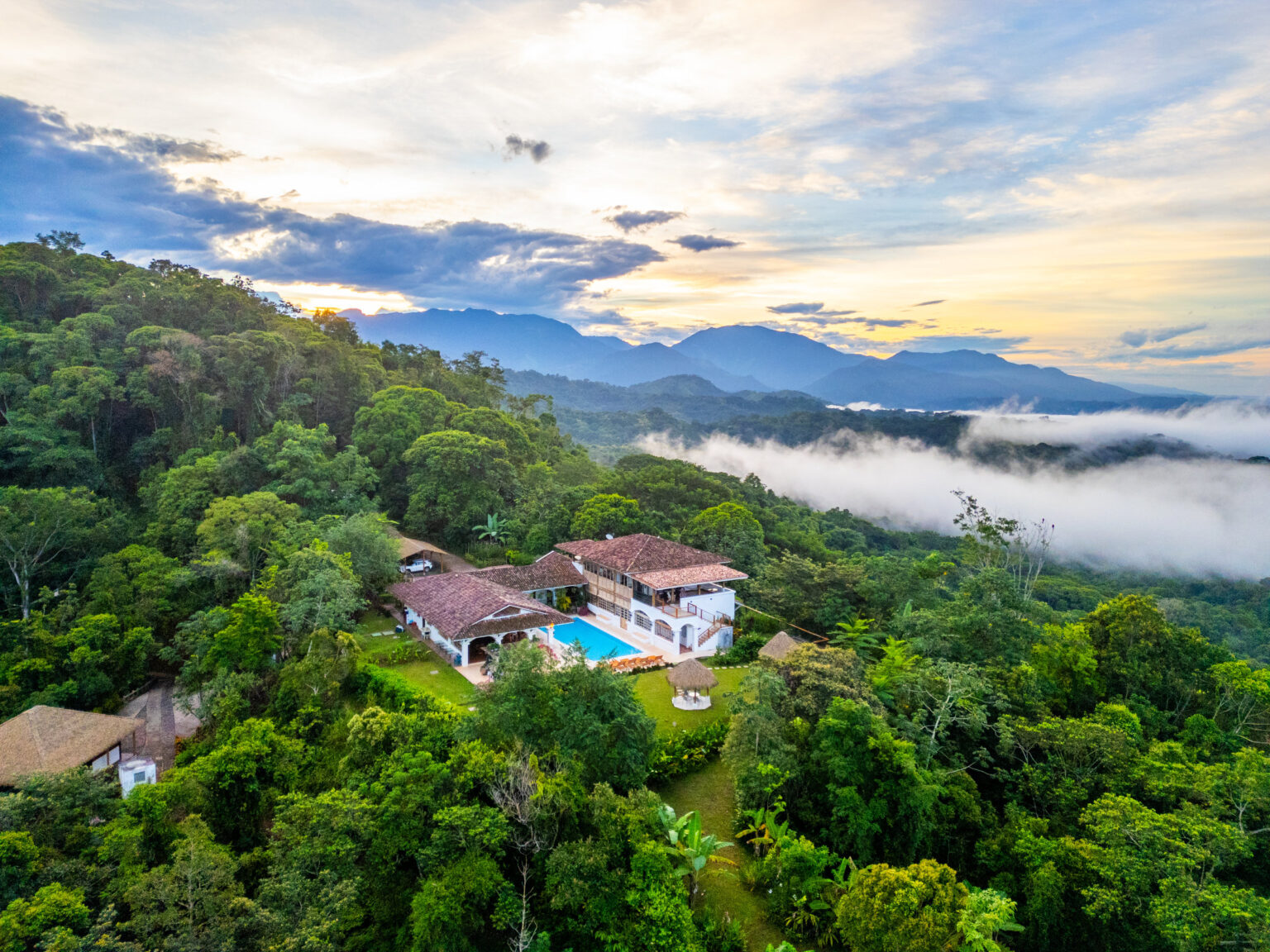 Aerial view of Hacienda Las Vainillas at sunset with mist rolling over the rainforest, Costa Rica