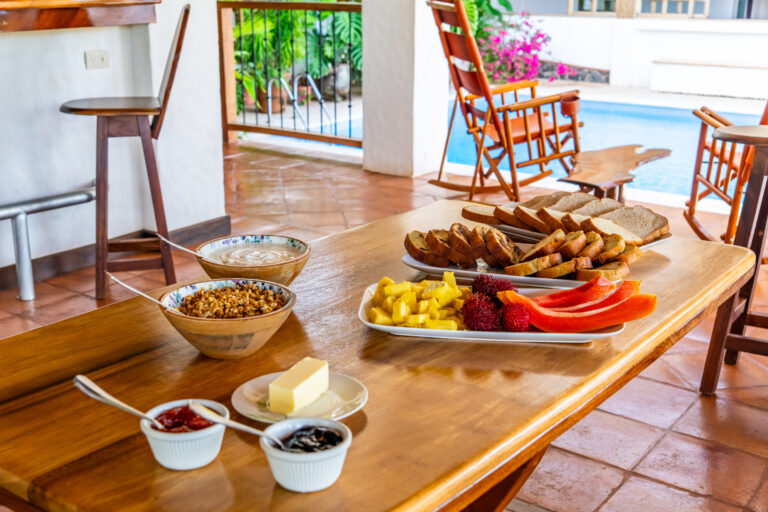 Breakfast spread of fresh fruit, bread and preserves on the terrace table, Costa Rica retreat