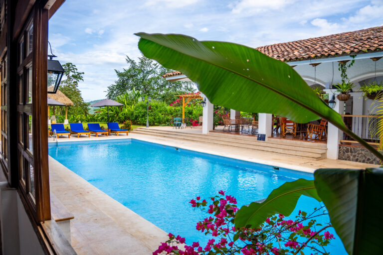 Swimming pool framed by banana leaves and bougainvillea at the hacienda, Costa Rica