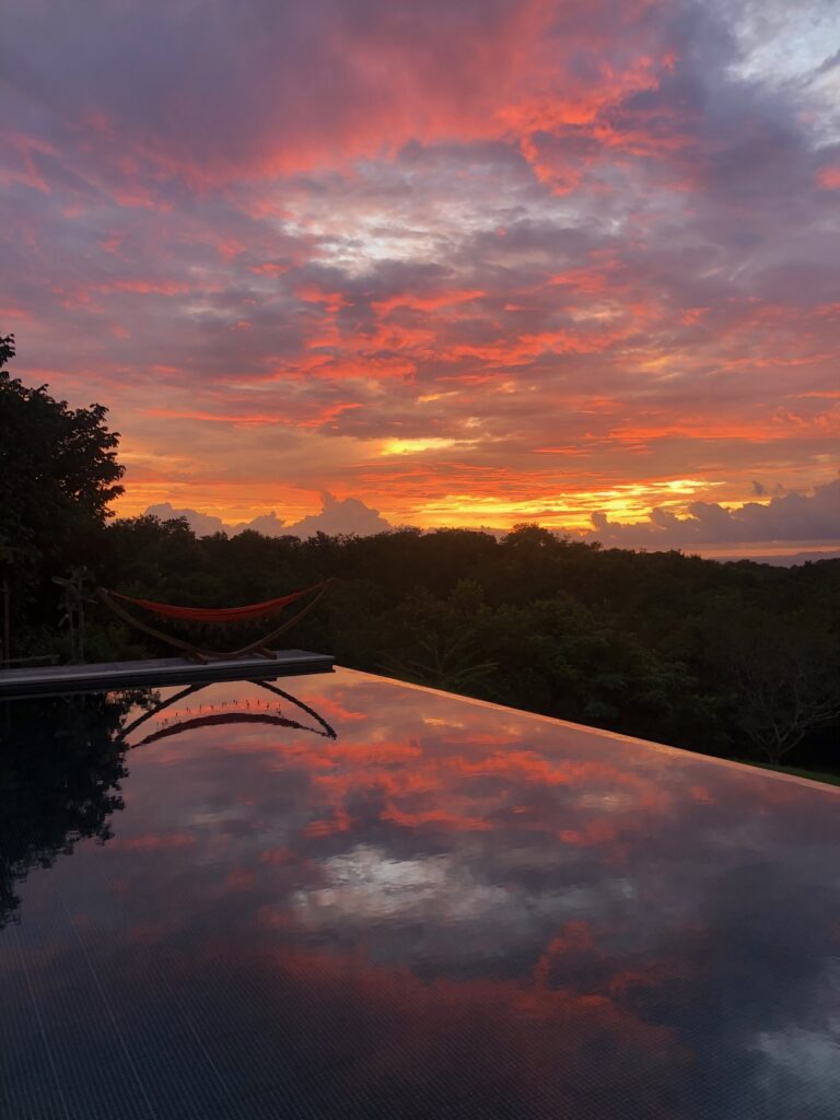 Infinity pool under a pink and orange sunset at Calamocha Lodge, Manzanillo