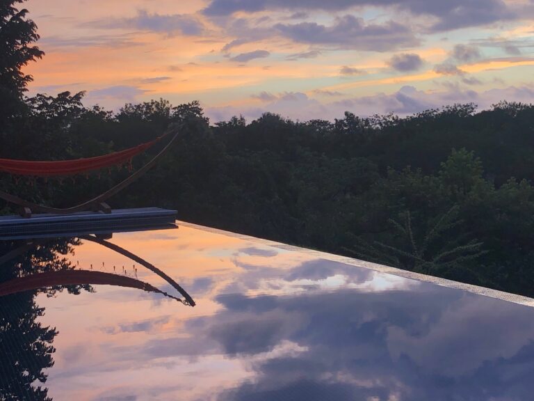Infinity pool reflecting the sunset sky above the jungle at Calamocha Lodge, Costa Rica