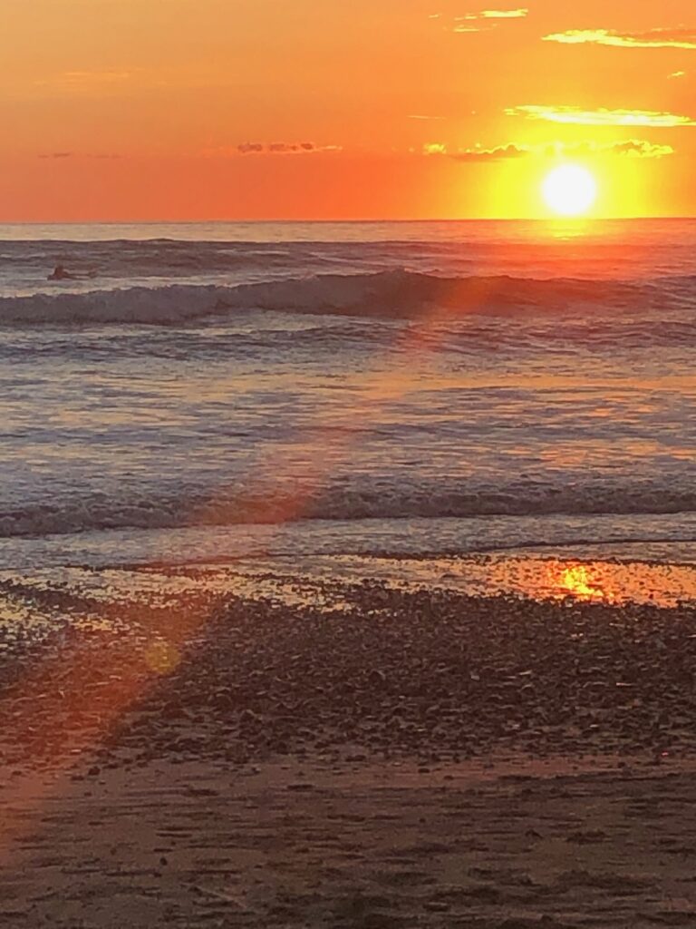 Sun setting over the Pacific with light on the wet sand, Manzanillo, Costa Rica