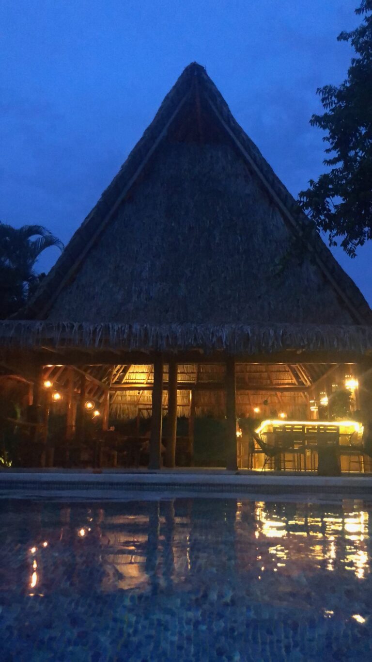 Thatched rancho glowing at night beside the pool at Calamocha Lodge, Costa Rica