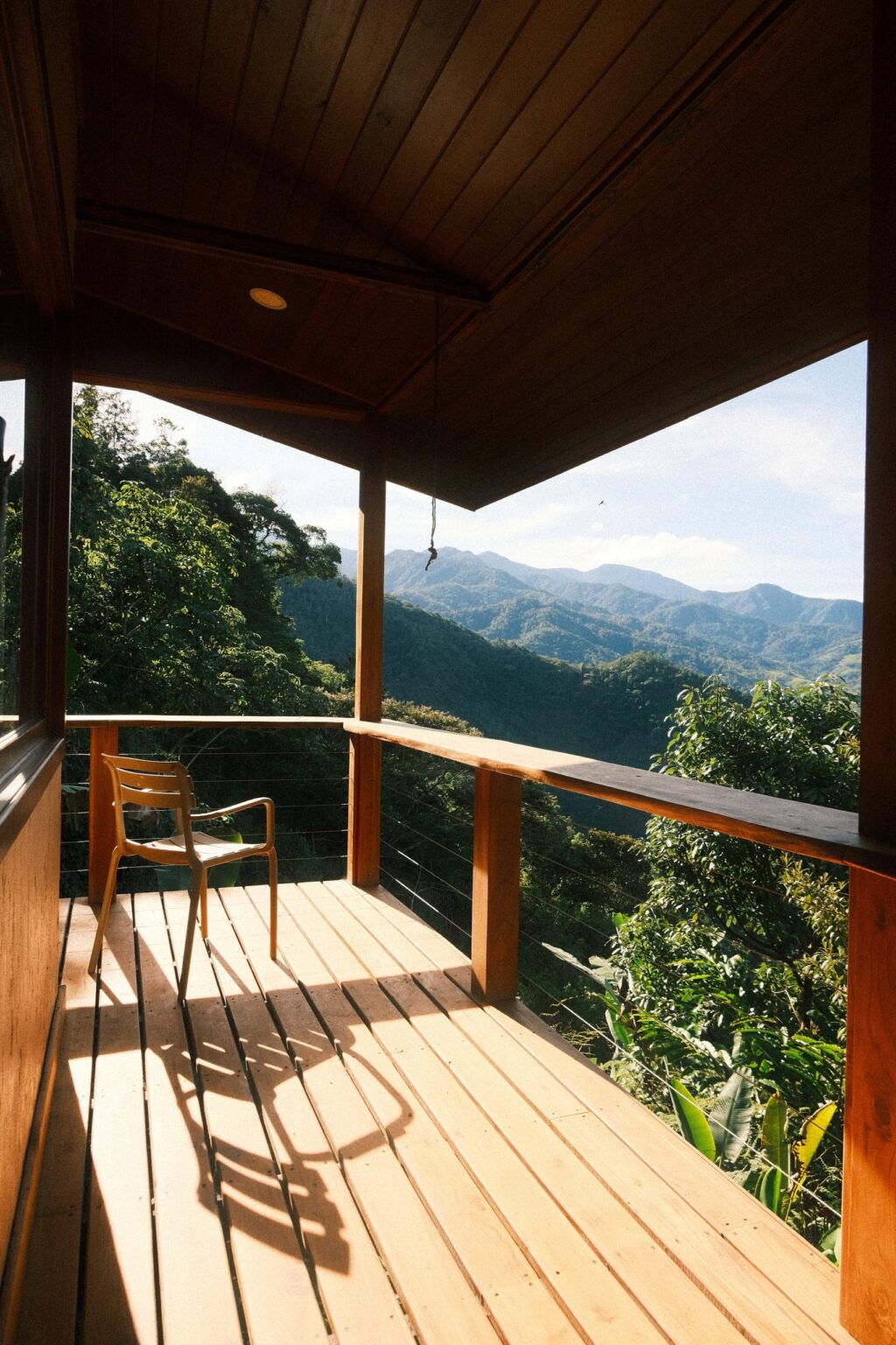 Wooden deck with chair facing the forest, Dharma Vida, Costa Rica