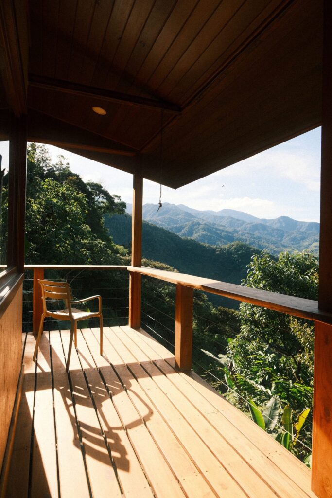 Wooden deck with chair facing the forest, Dharma Vida, Costa Rica
